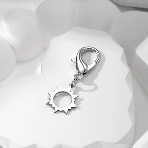 Detail of silver lobster clasp with sun pendant on white textured heart display stand