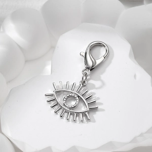 Macro shot of silver evil eye alloy pendant with lobster clasp on stone texture