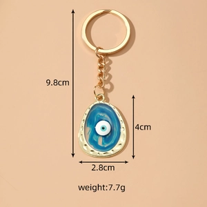 Irregular oval Evil Eye keychain with blue resin inlay and gold metal frame detailing