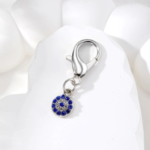 Dettaglio del ciondolo Evil Eye con cristalli blu e bianchi e chiusura a moschettone