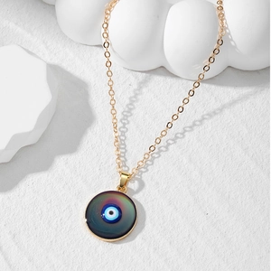 Λεπτομέρεια χρυσού κολιέ Evil Eye με μενταγιόν διαβάθμισης χρωμάτων σε λευκό φόντο
