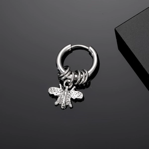 Detailed macro view of silver steel hoop earring with honey bee charm and small rings