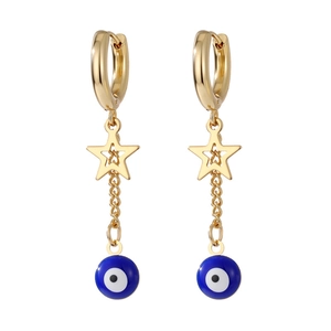 Detail shot of golden star drop earrings with blue evil eye beads and heart cutout