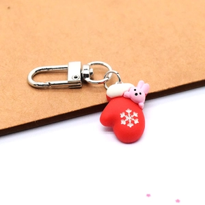 Detailed view of a red festive resin glove keychain with a cute pink bunny and snowflake