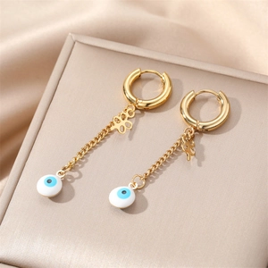 Detailed view of gold evil eye drop earrings with cross chain on a jewelry stand