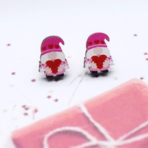 Detalle de los pendientes de madera con gnomos de San Valentín sobre fondo de regalo