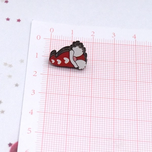 Vista macro detallada de un pendiente de corazón de madera rojo y blanco de 1,5 cm en escala
