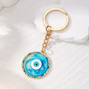 Golden Evil Eye keychain featuring a round blue and white gradient resin pendant on a white base