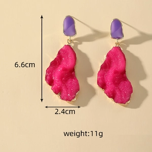 Detailed view of chunky resin earrings featuring pink mineral texture and gold edging