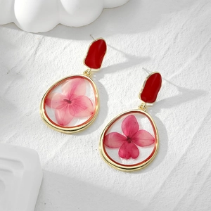 Golden geometric earrings with red enamel studs and pink dried flower resin droplets