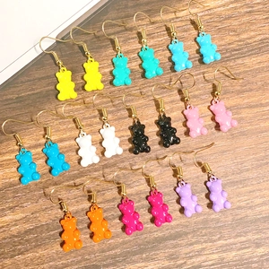 Bunte Harz-Gummibärchen-Ohrringe in zehn lebhaften Farben mit goldenen Haken auf Holz