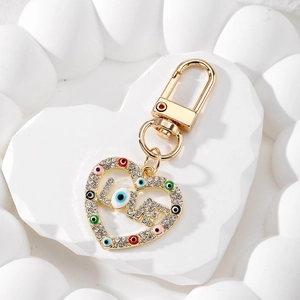 Detail of gold LOVE heart keychain with rhinestones and colorful evil eye beads