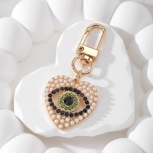 Détail du porte-clés cœur œil protecteur avec perles blanches et fermoir doré