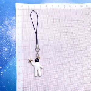 Detailed view of astronaut charm with gold star on a measurement grid backdrop