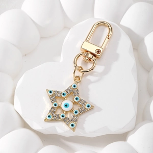 Macro shot of gold star-shaped Evil Eye keychain with sparkling white rhinestones