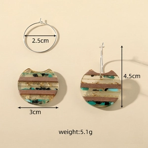 Detail view of cat-shaped wood and resin earrings with dimensions and weight specs