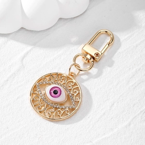 Vintage hollow pattern evil eye keychain with pink resin eye and sparkling rhinestones