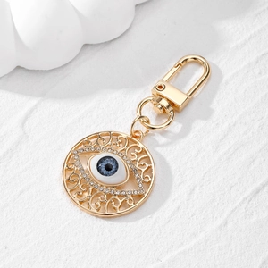 Detailed close-up of a golden Evil Eye keychain with blue enamel and sparkling rhinestones