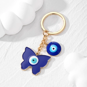 Détail d'un porte-clés doré avec papillon œil bleu et breloques cœur en alliage