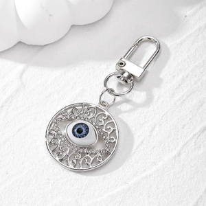 Detail of vintage silver Evil Eye keychain with hollow patterns and sparkling rhinestones