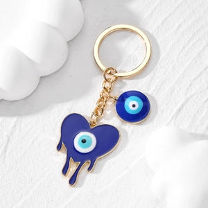 Porte-clés cœur œil bleu avec effet fondu et anneau doré sur fond de pierre