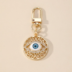 Vintage evil eye keychain with hollow filigree and sparkling rhinestones in gold finish