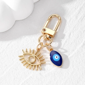 Vue détaillée du porte-clés œil protecteur avec cils dorés et pendentif en émail bleu