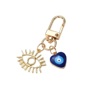 Porte-clés œil en or avec breloque de cils ajourée et pendentif cœur émaillé bleu