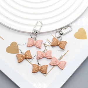 Pink and brown resin bow earrings and charms with white polka dots on silver hooks
