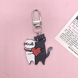 Détails de porte-clés en acrylique avec deux chats mignons tenant un cœur à pois rouges