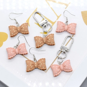 Polka dot bow jewelry set featuring pink resin earrings and matching keychain pendants