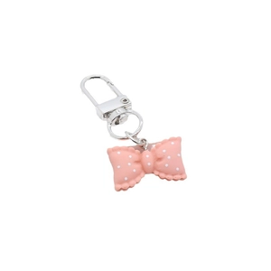 Pink resin bow keychain with white polka dots and silver swivel clasp on white background