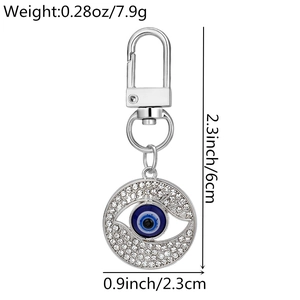 Detail of silver evil eye keychain with rhinestones and size measurements 6cm by 2.3cm