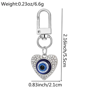 Detail view of heart-shaped evil eye keychain with white rhinestones and blue resin eye