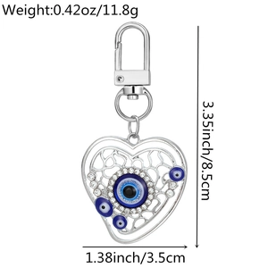 Detail view of heart-shaped evil eye keychain with silver alloy and blue charms