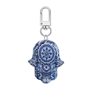 Detail of blue Hamsa hand keychain with mandala pattern and evil eye protective symbol