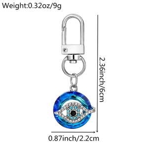Detail view of Evil Eye keychain with blue crystal, silver hardware and product dimensions