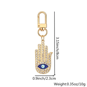 Detailed view of gold Hamsa hand keychain with evil eye charm, sized 8cm by 2.3cm