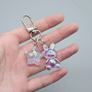 Detail of colorful resin rabbit charm and purple glitter star on silver lobster clasp