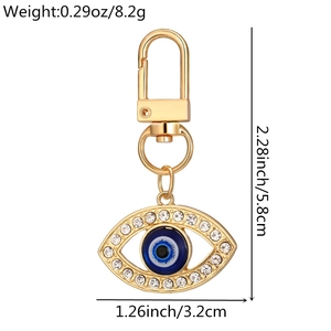 Detail view of gold evil eye keychain with rhinestones showing 5.8cm size and 8.2g weight