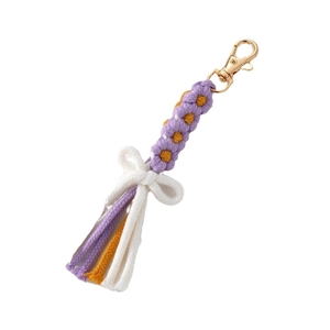 Portachiavi a fiore intrecciato a mano con fiocco viola e nappa su sfondo bianco