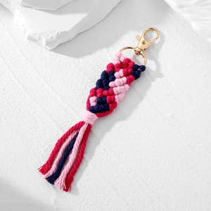 Detailed macro view of bohemian hand-woven macaron cotton rope keychain with gold metal clasp