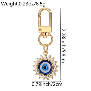 Detailed close-up of golden evil eye keychain with sparkling crystal inlay and size info
