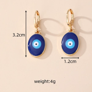 Détail des boucles d'oreilles œil du démon dorées avec mesures de 3,2 cm de hauteur