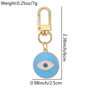 Detail of blue evil eye keychain with gold eyelashes showing 6cm length measurements