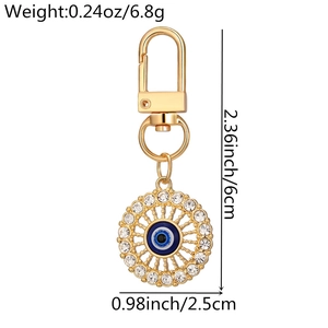 Detailed view of hollow evil eye keychain with gold plating and clear rhinestones
