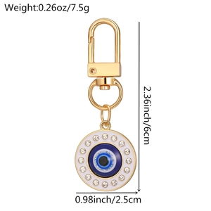 Detail view of Evil Eye keychain featuring a gold finish with rhinestones and blue eye charm
