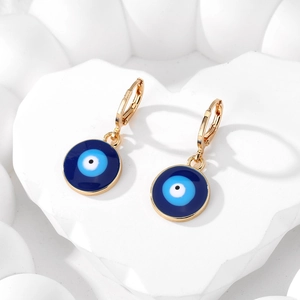 Vue détaillée d'une boucle d'oreille dorée avec pendentif œil bleu en émail et levier