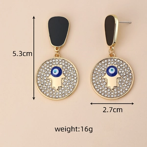 Détail des boucles d'oreilles Hamsa et Œil Mauvais, dimensions 5,3 cm de haut et 2,7 cm de large