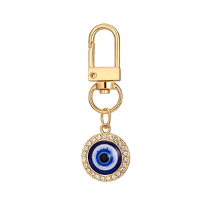 Golden Evil Eye keychain with blue crystal pendant and sparkling rhinestones on white background